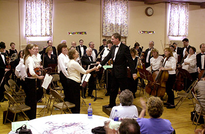Conductor Isaacson shakes hands with concertmaster Kelly