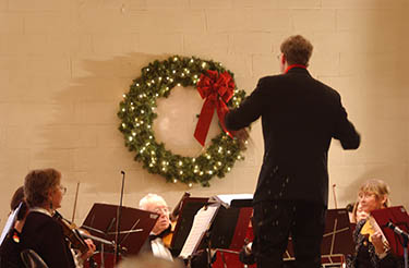 Larry Isaacson contucts in front of wreath